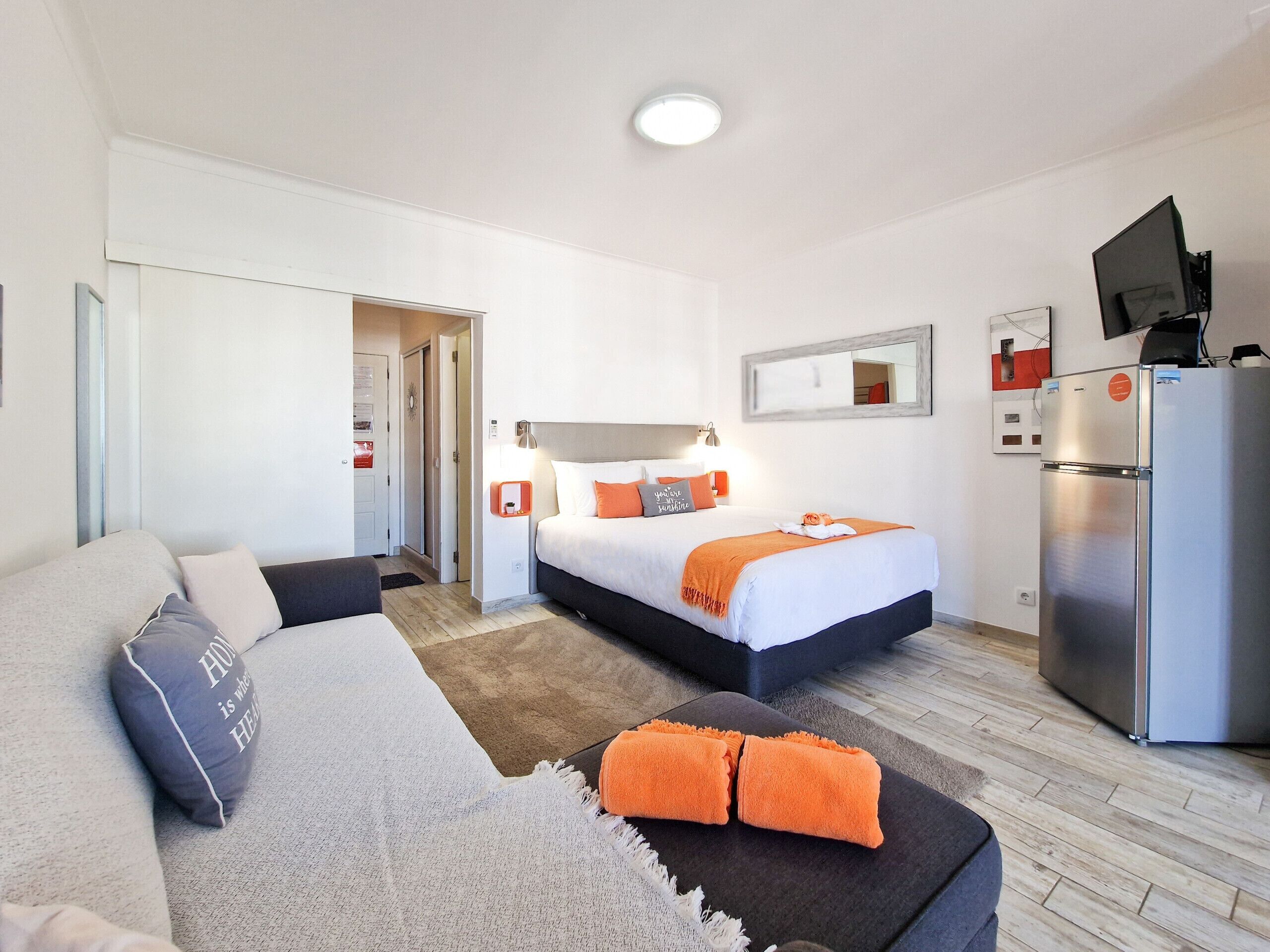 Une chambre d’hôtel équipée d’un lit, d’un canapé, d’une télévision et d’un réfrigérateur.
