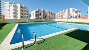 A rooftop swimming pool with a clear view of surrounding high-rise buildings.