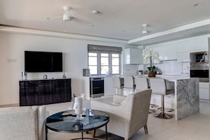Relax in this open-plan living space with a central island, comfortable seating area, and large flat-screen TV.