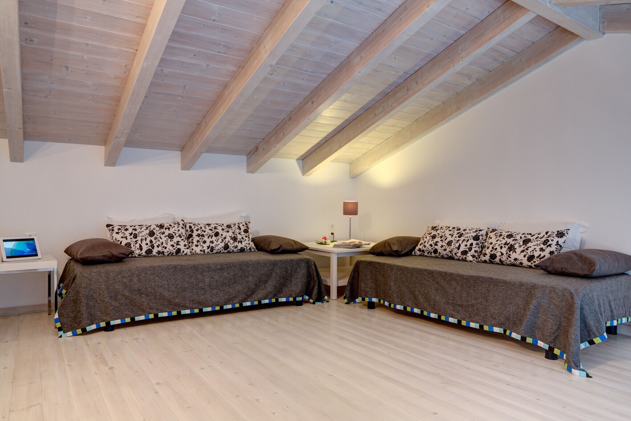 Ein Schlafzimmer mit zwei Betten, einem Schreibtisch und einer Lampe.