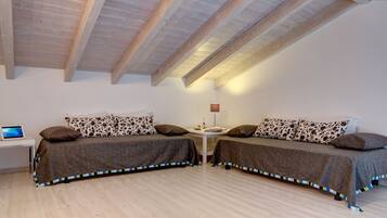 Ein Schlafzimmer mit zwei Betten, einem Schreibtisch und einer Lampe.