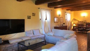 A living room with a sofa, a glass coffee table, and a stone fireplace. - Villa Gramigna: A charming two-story villa surrounded by the greenery. (Pontecuti)