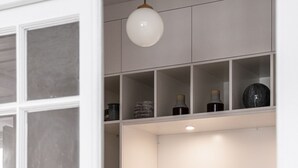 Een slaapkamer met een bed, een kledingkast en een hanglamp.