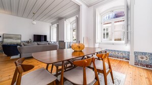 Een ruime woonkamer met een houten eettafel, een bank en een televisie.
