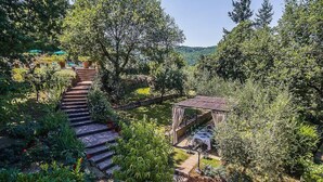 Un jardín con una escalera de piedra que lleva a un pabellón.