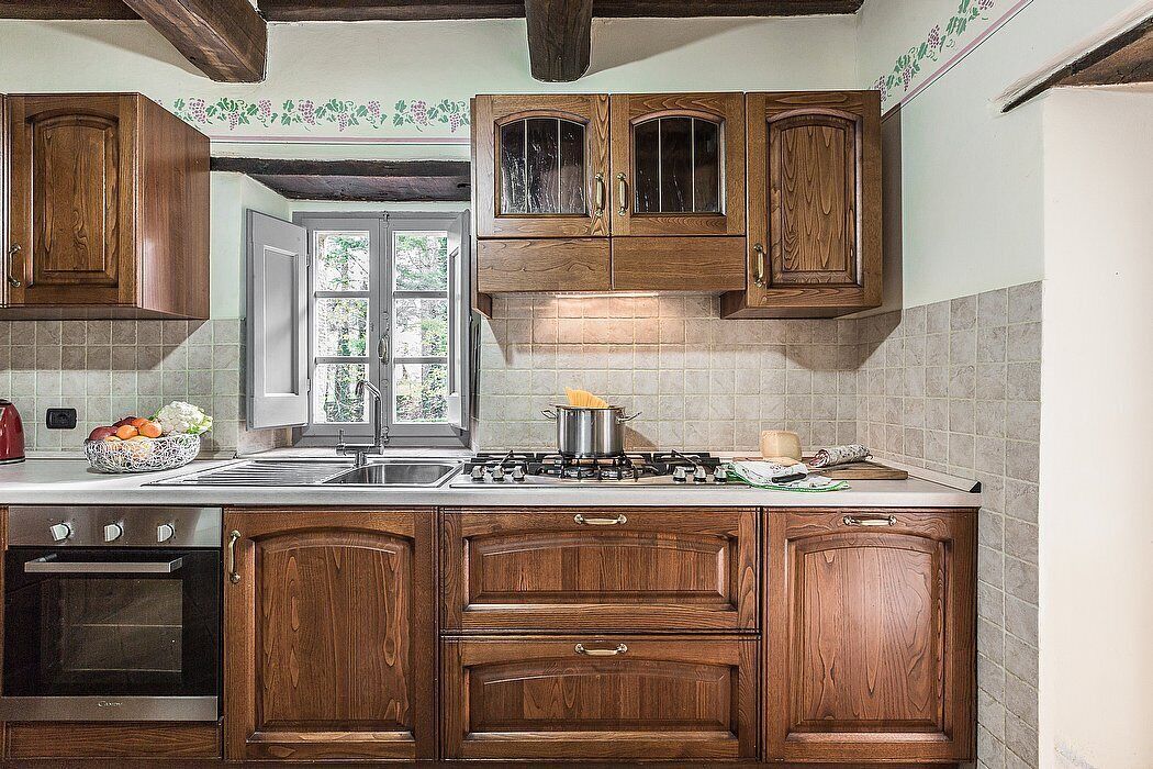 A kitchen with wooden cabinets, a stove, and a window.