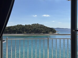 A balcony with a view of a clear blue sea and a small island with dense greenery. - Studio apartment in Tribunj with Seaview, Balcony, Air condition, WIFI (68-1) (Tribunj)