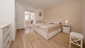 A bedroom with a bed, bedside tables, a wardrobe, and a view through a glass door. - Apartment in Palit with Terrace, Air condition, WIFI, Dishwasher (820-3) (Palit)