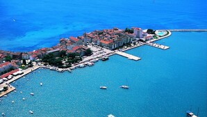 Vue aérienne d’une ville côtière avec un port de plaisance, des bâtiments et des bateaux.