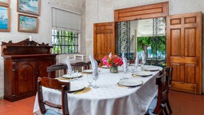 A dining area with a round table set for six, surrounded by wooden chairs. - Traditional Beachfront Style - Clearwater (Gibbes Beach)