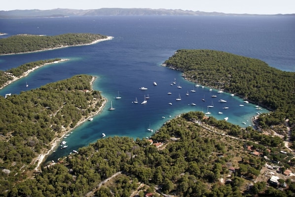 An aerial view of a coastal area with clear turquoise waters, surrounded by dense green forests and small islands. - Robinson home in Bol with Seaview, Terrace, Air condition, WIFI (3414-1) (Bol)