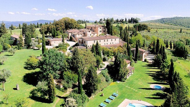 A large estate with multiple buildings, a well-maintained lawn, and a swimming pool.