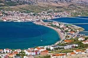 A coastal town with a mix of residential and commercial buildings, a marina, and a curved coastline.