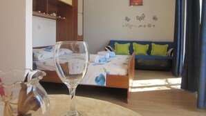 Quarto com uma cama, um jarro de vidro e um ventilador de teto.