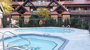 Une piscine équipée d’un poste de surveillance pour sauveteur et d’un panneau indiquant qu’il est interdit de plonger.