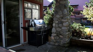 Un pilier en pierre avec une grille fixée au mur extérieur d’une maison.
