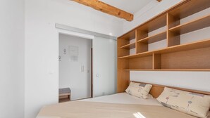 A bedroom with a bed, wooden headboard, and built-in shelves. - Apartment in Sukošan with Seaview, Terrace, Air condition, WIFI (3495-5) (Sukošan)