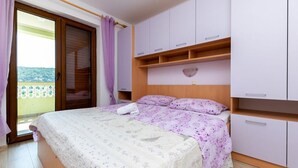 Un dormitorio con cama, armario y balcón.
