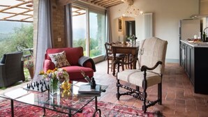 Un vaste espace de vie comprenant un canapé rouge, une table basse en verre et une table à manger avec des chaises.