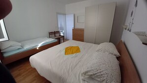 Une chambre à coucher avec un lit, une commode en bois et une armoire.