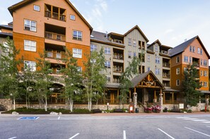 Un hôtel à plusieurs étages, doté de balcons, d’une façade en pierre et d’une entrée en bois.