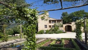 A stone building with a courtyard, surrounded by lush greenery and a small pond. - Montestigliano, an authentic farmhouse in the heart of Tuscany, is an oasis of peace and beauty that offers its guests refined residences and an enchanting view (Sovicille)
