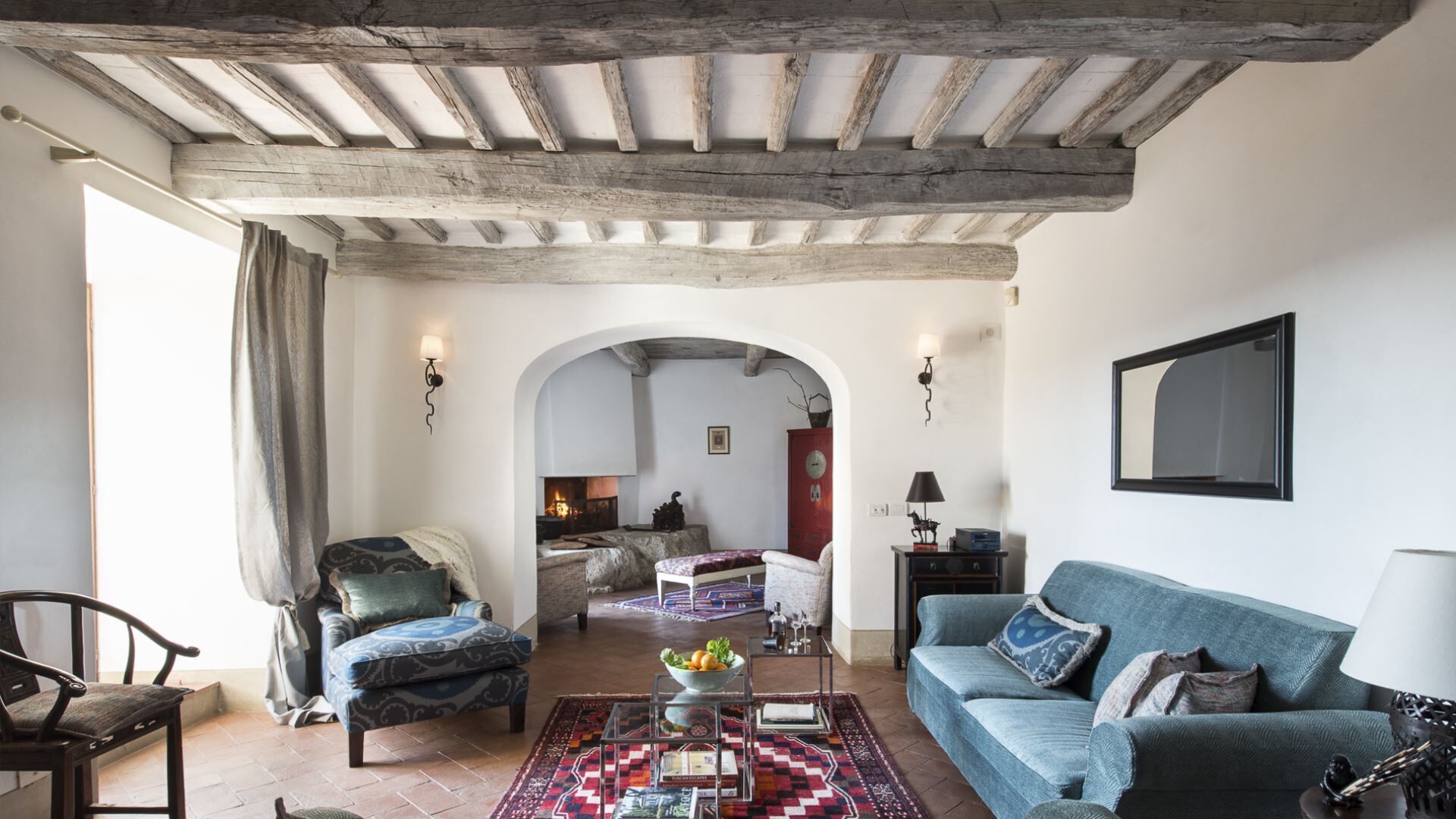 A cozy living room with a fireplace, a sofa, a chair, and a coffee table.