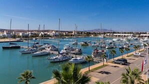 A marina with multiple boats docked, a parking area, and a clear blue sky. - Beautiful Sea View Apartment in Saidia 4268 (Saidia)