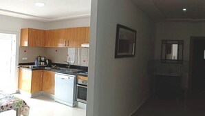 A modern kitchen with wooden cabinets, a dishwasher, and a tiled backsplash. - Beautiful Sea View Apartment in Saidia 4268 (Saidia)