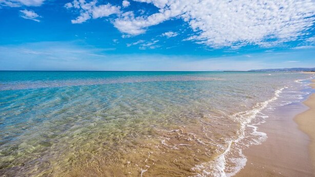 A beach with clear shallow waters, a sandy shore, and a partly cloudy sky. - Beautiful Sea View Apartment in Saidia 4268 (Saidia)