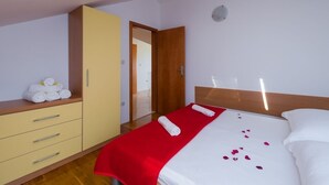 Habitación de hotel con cama, armario y puerta que da a otra habitación.
