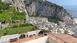 Una cittadina costiera con edifici a terrazze, una chiesa imponente e vista sul mare.