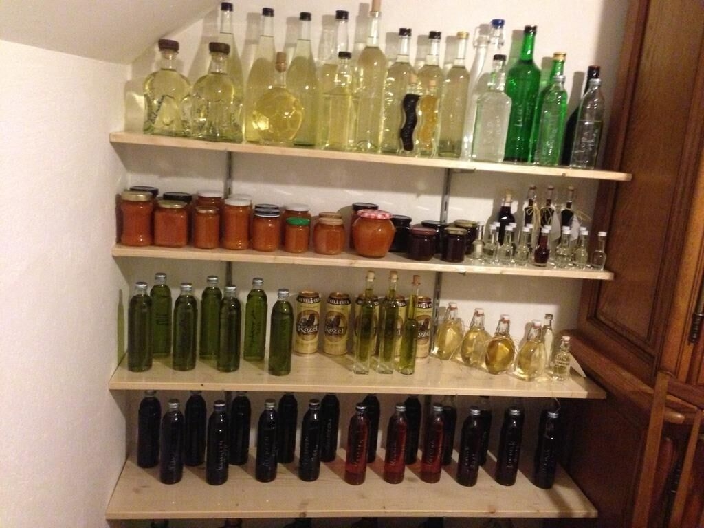 A shelf with various bottles and jars, likely containing condiments or beverages.