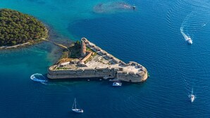 An aerial view of a fortified island with a lighthouse, surrounded by clear blue waters and boats. - Apartment in Grebaštica with Seaview, Balcony, Air condition, WIFI (3571-2) (Grebaštica)