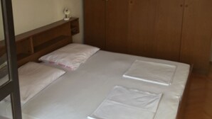 Une chambre à coucher avec un lit superposé, une armoire en bois et une petite table de chevet.