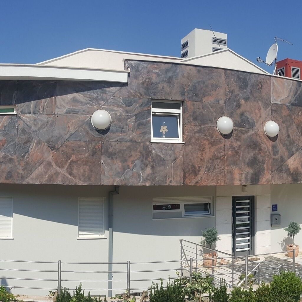 A modern building with a flat roof, satellite dish, and a small window with a flower decoration.