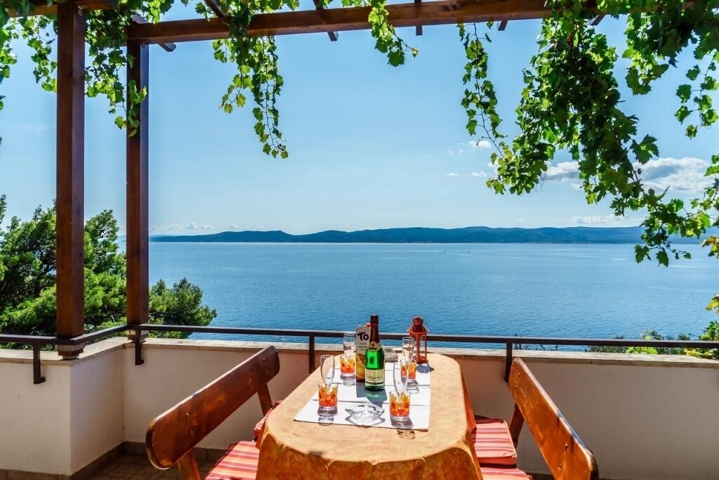 A table set for two with a view of a lake and mountains in the background.