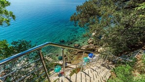 A staircase leading to a rocky area with clear blue water and a view of distant mountains. - Apartment in Pisak with Seaview, Terrace, Air condition, WIFI (102-4) (Pisak)