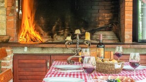 An outdoor dining area with a brick oven, a table set with plates, glasses, and a basket of bread. - Apartment in Nin with Terrace, Air condition, WIFI (864-4) (Nin)