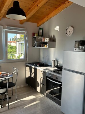 Een koelkast, een oven, een kookplaat, een koffiezetapparaat/waterkoker