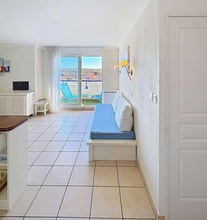 Une chambre avec un lit, une télévision, une petite table et une vue sur l’extérieur.