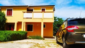 A two-story yellow building with a car parked in front. - Apartment in Vir with Terrace, Air condition, WIFI (4594-1) (Vir)