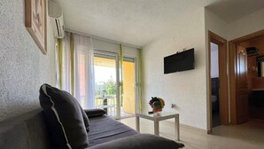 A living room with a sofa, a small table with a vase, a flat-screen TV mounted on the wall, and a sliding glass door leading to an outdoor area. - Apartment in Zaton (Zadar) with Terrace, Air condition, WIFI, Washing machine (4141-3) (Nin)