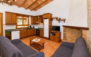 Cozinha moderna com armários de madeira, espaço de jantar com mesa e lareira embutida.