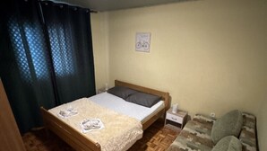 A bedroom with a wooden bed, a small bedside table, a couch, and a window with curtains. - Apartment in Seline with Seaview, WIFI, Washing machine (4209-1) (Seline)