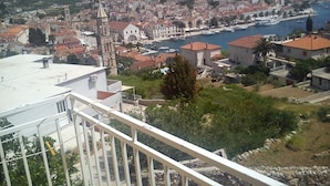 Une ville côtière dotée d’un imposant clocher d’église, d’un port de plaisance avec des bateaux, et d’un mélange de bâtiments résidentiels et commerciaux.