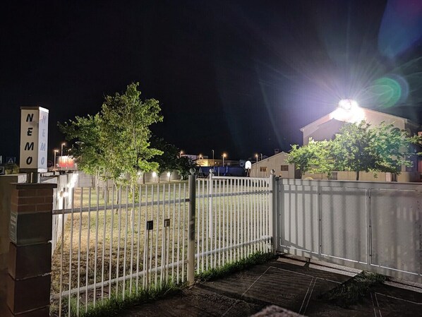 A gated area with a sign reading 'NEMO' and a building in the background.