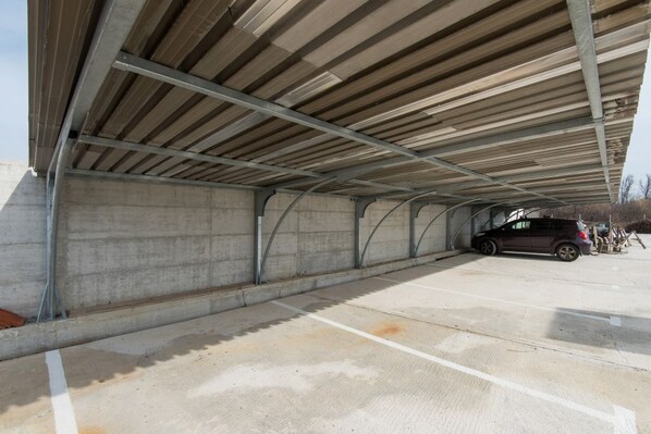 A covered parking area with concrete walls and a metal roof structure. - Apartment in Privlaka with Seaview, Balcony, Air condition, WIFI (3598-2) (Privlaka)