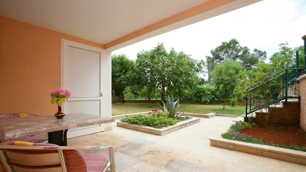An outdoor patio with a table and chairs, surrounded by a garden and a staircase. - Studio apartment in Poreč with Terrace, WIFI (3794-1) (Porec)