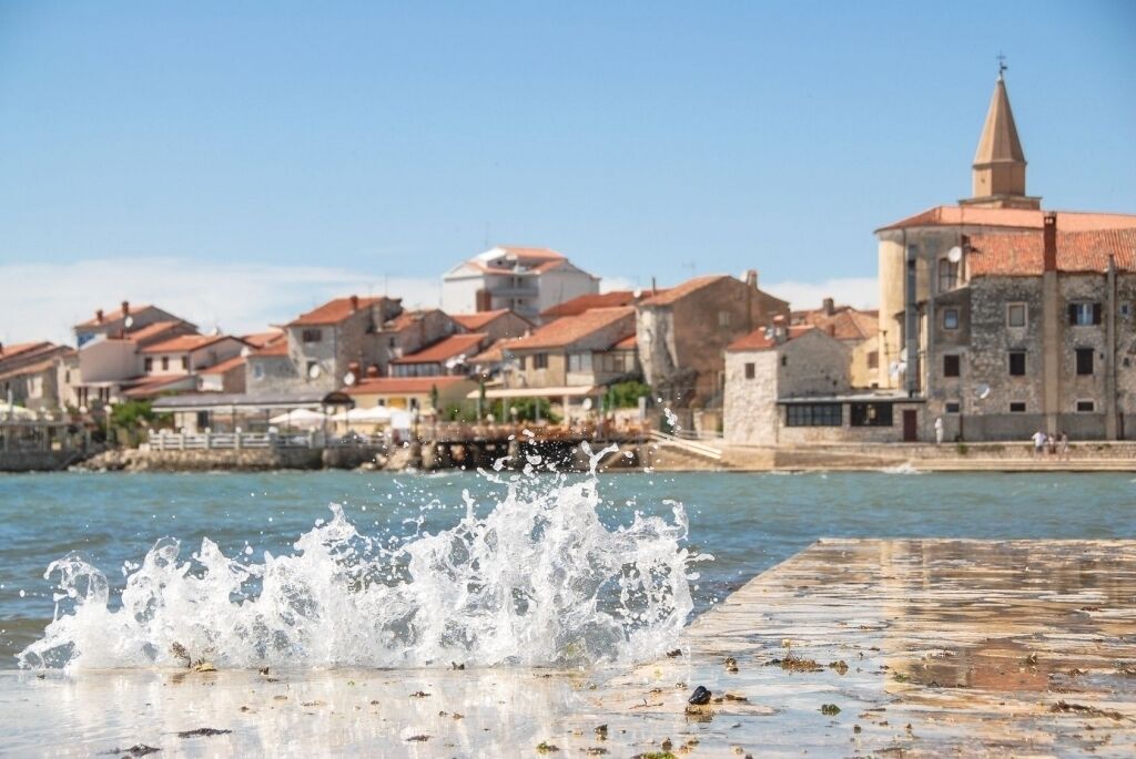 A waterfront view with buildings and a splash of water.